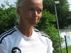 Corina Reinisch spielt den Ball durch die Tore hindurch knapp rechts am Loch ...